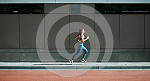 Young woman, running and city sidewalk with training, exercise and fitness on urban road. Street, runner profile and