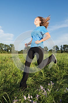 Young woman running on the grass