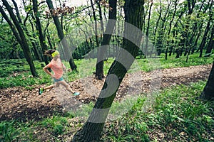 Young woman running in green forest. Endurance sport.