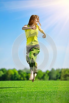 Young woman running on a green meadow