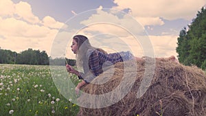 Young woman running and jumping on the haystack