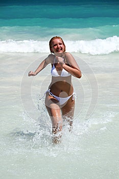Young woman running out of ocean