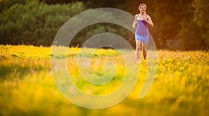 Young woman running outdoors on a lovely sunny summer evenis