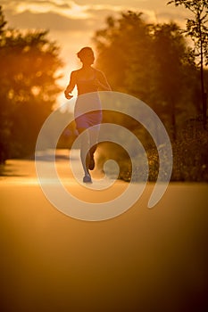 Young woman running outdoors on a lovely sunny summer evenis