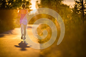 Young woman running outdoors on a lovely sunny summer evenis