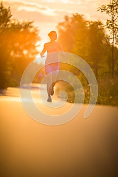 Young woman running outdoors on a lovely sunny summer evening