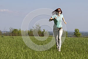 Young woman running on spring meadow