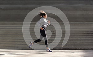 Young woman running by stairs