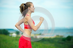 Young woman running summer park rural road