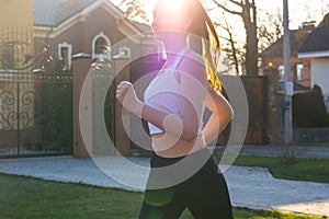 Young woman running in sunlight at sunset