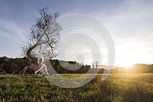 Young woman running into sunset