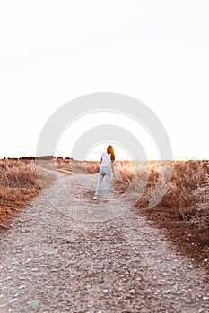 Young woman running at sunset in the field