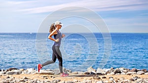 Young woman running on trail near the ocean coast