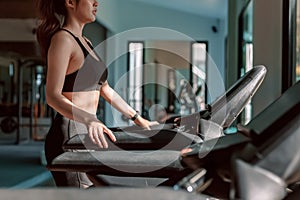 Young woman running treadmill at gym for cardio. Fitness workout concept