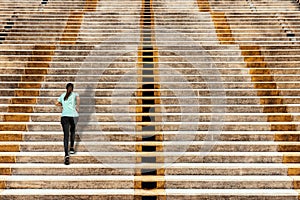 Woman running up in urban stairs concrete background