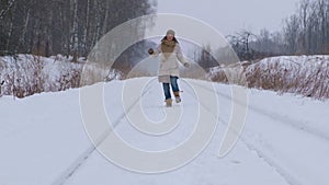 Young woman runs in the snow in a winter park