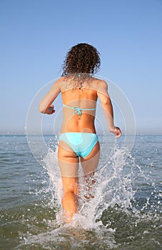 Young woman runs on water from back