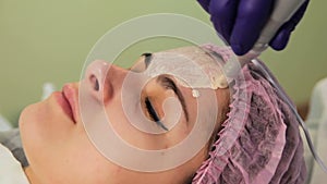 The young woman`s face during the procedure closeup. Innovative cosmetic procedure. Medical procedure rejuvenation.