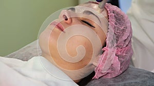 The young woman`s face during the procedure closeup. Innovative cosmetic procedure. Medical procedure rejuvenation.