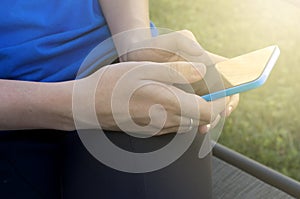 Young Woman`s Hand Holding a Cellular Phone with Sunlight