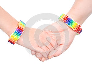 Young woman's hands with a bracelet patterned as the rainbow flag. isolated on white