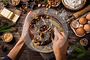 Young woman`s hands cooking christmas fruit cake. Wooden table w