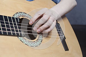 Young woman`s hands playing a acoustic classic guitar