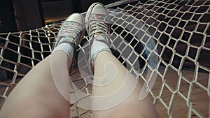 Young woman`s legs relaxing on the hammock in her loft apartment