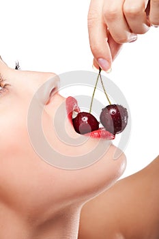 Young woman's mouth with red cherries