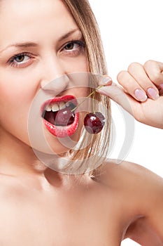 Young woman's mouth with red cherries
