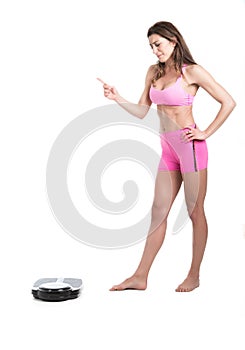 Young woman sad and furious on weight scales. Fit and healthy concept. Isolated over white background