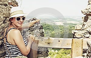 Young woman in a sailor outfit is showing into the distance from