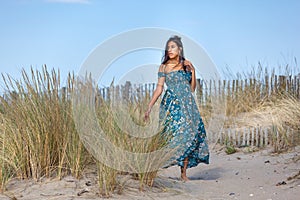 YOUNG WOMAN ON THE SAND OF THE BEACH