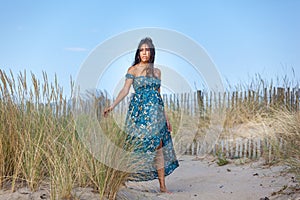 YOUNG WOMAN ON THE SAND OF THE BEACH