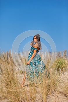 YOUNG WOMAN ON THE SAND OF THE BEACH