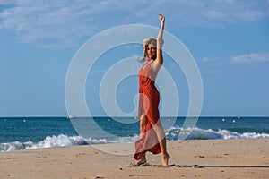 YOUNG WOMAN ON THE SAND OF THE BEACH