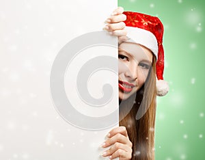 Young woman in santa claus hat with christmas card