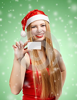 Young woman in santa claus hat with christmas invitation card