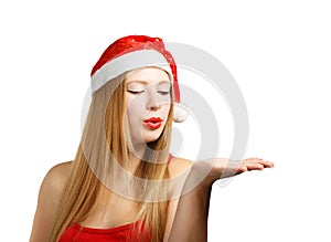 Young woman in santa hat blows on open hand