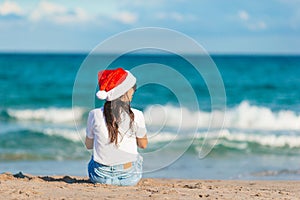 Young woman in Santa hat on Christmas beach holidays