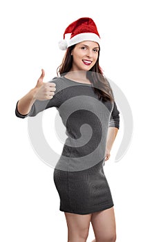 Young woman with Santa hat smiling and giving thumb up