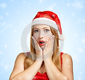 Young woman in santa hat surprised