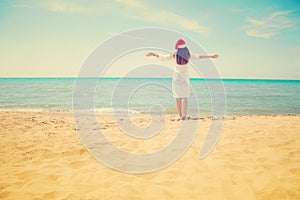 Young woman in santa hat on tropical beach. Christmas vacation. Christmas beach vacation travel woman wearing Santa hat and bikini