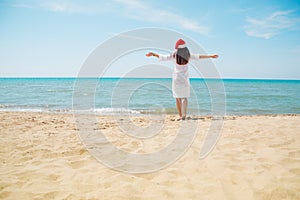 Young woman in santa hat on tropical beach. Christmas vacation. Christmas beach vacation travel woman wearing Santa hat and bikini