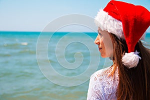 Young woman in santa hat on tropical beach. Christmas vacation. Christmas beach vacation travel woman wearing Santa hat and bikini