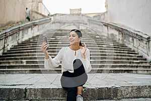 Young woman saying greetings on a video chat call meeting.Using a video meeting platform to stay connected.Smartphone app