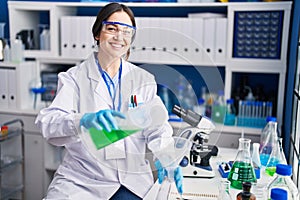 Young woman scientist measuring liquid at laboratory