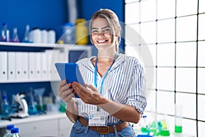 Young woman scientist using touchpad working at laboratory