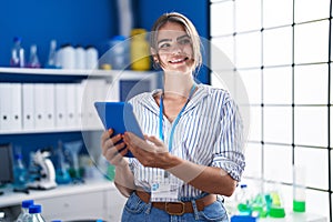 Young woman scientist using touchpad working at laboratory