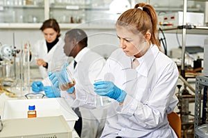 Young woman scientist working in research laboratory performing experiments